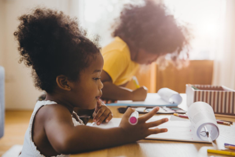 Photo of two children doing schoolwork at home