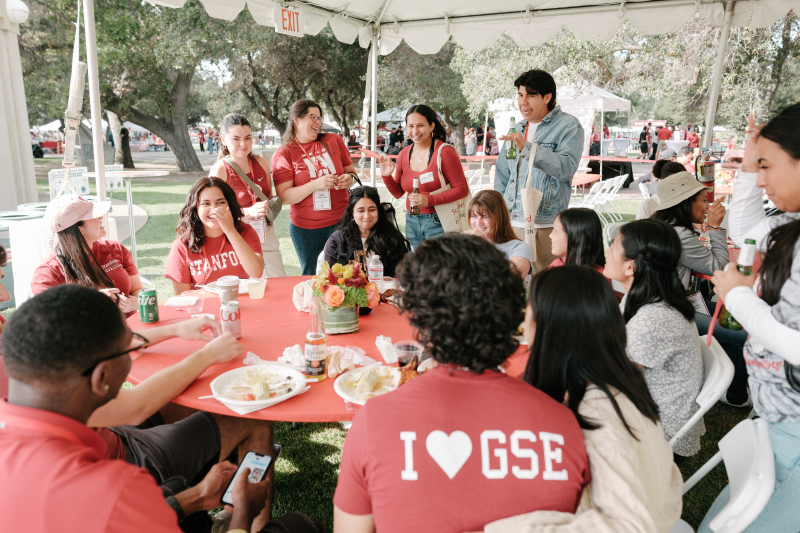 Alumni sitting around table at Tailgate during Reunion Homecoming