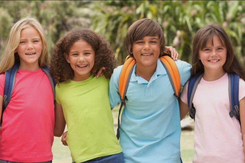 Four kids together smiling.