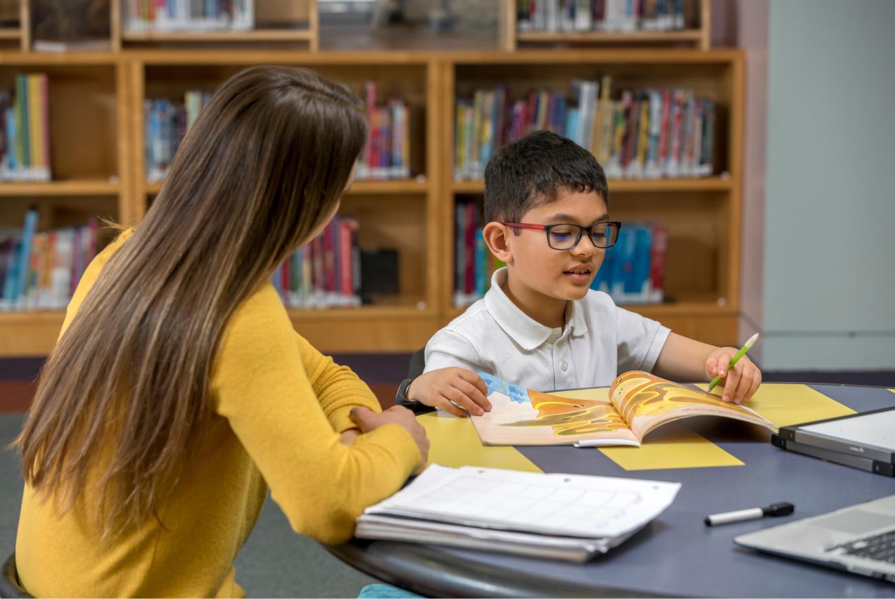 A tutor sitting with a young reader