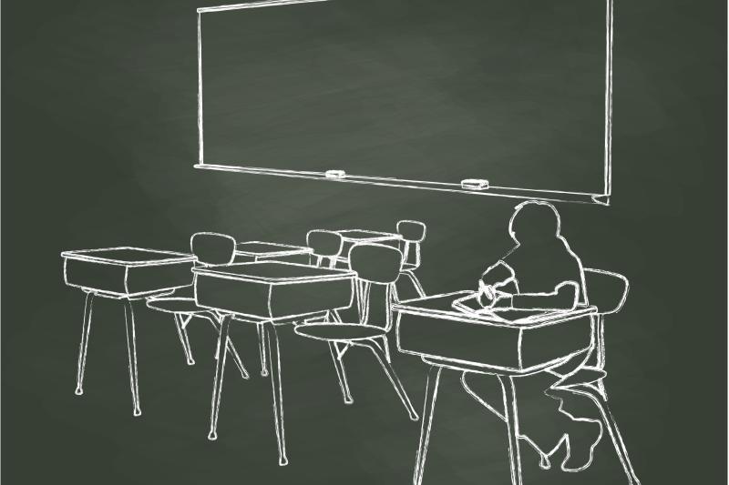 Photo of child in classroom with empty desks