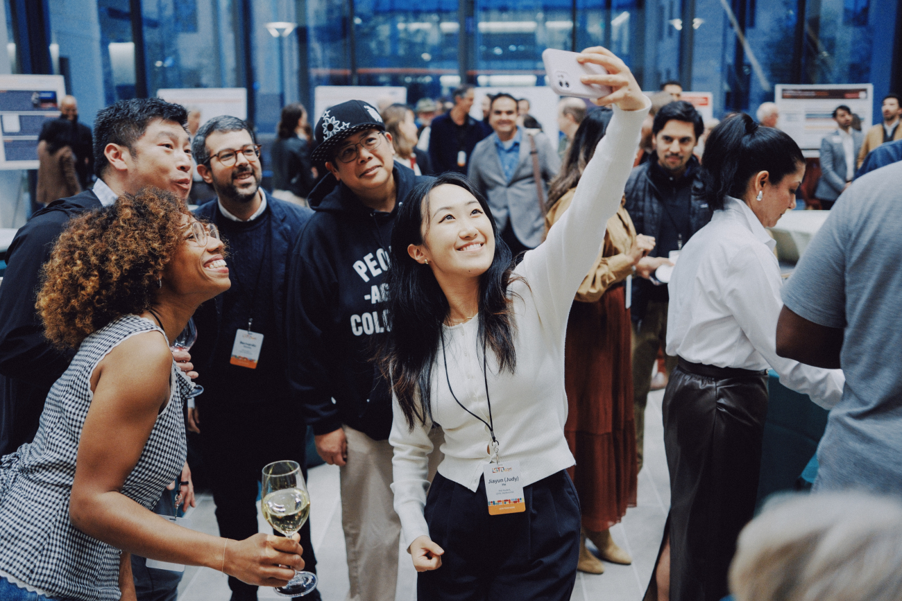 Picture of a student taking a selfie with several other alumni and students